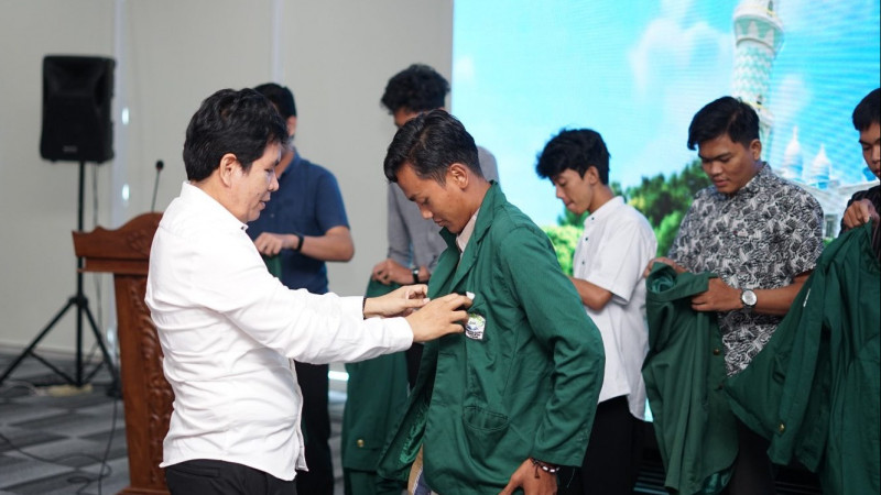 Dekan FEBI UIN RIL, Prof Tulus lakukan penyematan jaket almamater sebagai tanda pelepasan mahasiswa magang internasional.