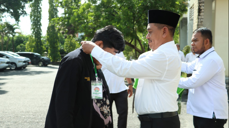 Rektor IAIN Langsa Prof. Dr. Ismail Fahmi Arrauf Nasution, MA saat menyematkan tanda peserta secara simbolis kepada peserta KKN.