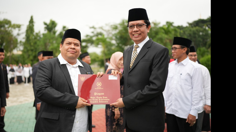Rektor Prof. H. Wan Jamaluddin Z, M.Ag., PhD menyerahkan penghargaan Satyalancana kepada Dr. Safari Daud M.Sos.I sebagai salah satu penerima Satyalanc